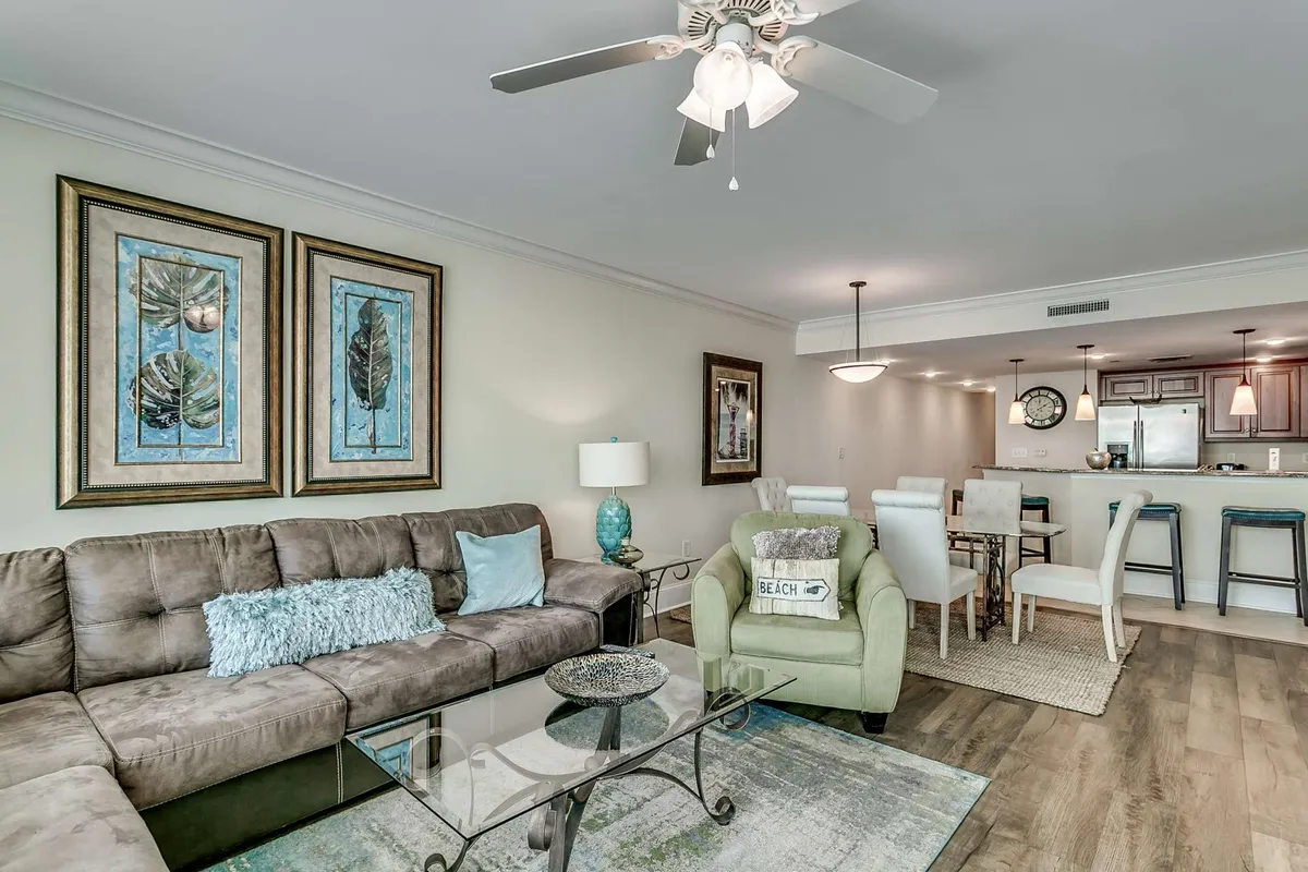 A cozy living space that integrates a comfortable sofa, decorative art pieces, and the kitchen island in the background. The setting invites both relaxation and social gatherings, highlighting the open concept between cooking and living areas.
